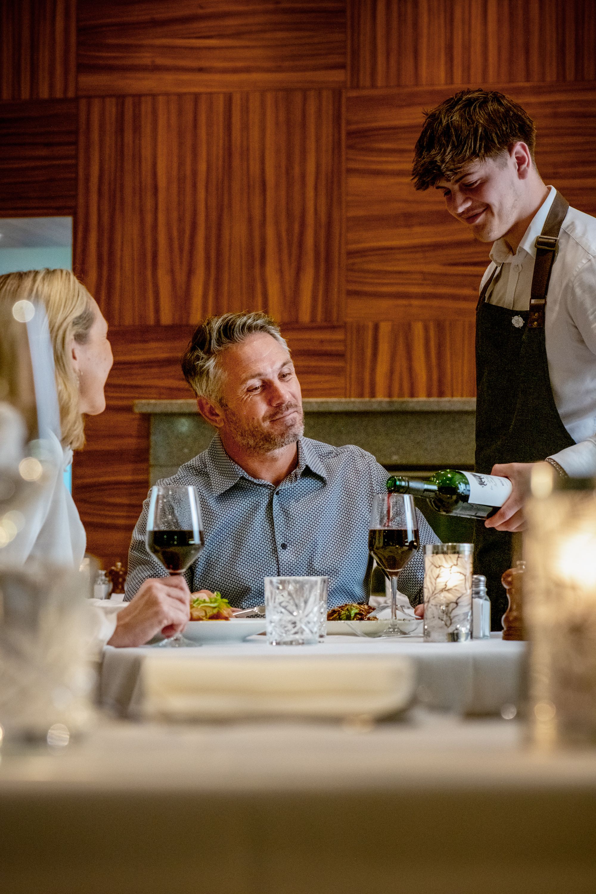 waiter pouring water for happy people